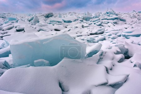 Foto de Paisaje invernal al amanecer de fragmentos de hielo azul y costa cubierta de nieve del lago Michigan, Empire Beach, Sleeping Bear Dunes, Michigan, EE.UU. - Imagen libre de derechos