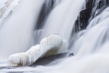 Foto de Winter, Bond Falls capturado con desenfoque de movimiento y enmarcado por el hielo y la nieve, Península Alta de Michigan, EE.UU. - Imagen libre de derechos