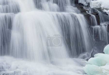 Winter, Bond Falls captured with motion blur and framed by ice and snow, Michigan's Upper Peninsula, USA