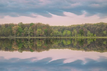 Téléchargez les photos : Paysage printanier à l'aube du littoral du lac Deep avec des reflets miroirs en eau calme, Yankee Springs State Park, Michigan, États-Unis - en image libre de droit