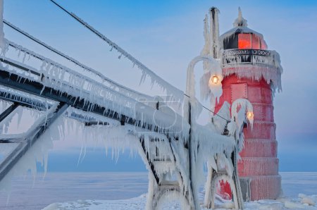Téléchargez les photos : Paysage hivernal à l'aube du phare de South Haven, Michigan, jetée et passerelle recouverts de glace, lac Michigan, États-Unis - en image libre de droit