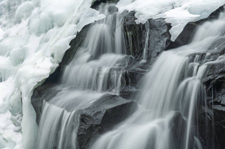 Hiver, Bond Falls capturé avec flou et encadré par la glace et la neige, Michigan Upper Peninsula, États-Unis
