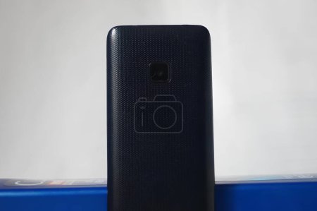 Téléphone portable noir minimaliste sur une boîte bleue. Photo de haute qualité