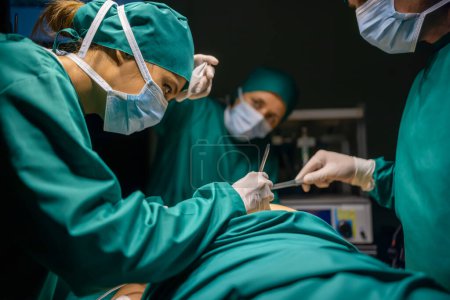 Téléchargez les photos : Équipe médicale asiatique effectuant une chirurgie en salle d'opération. - en image libre de droit