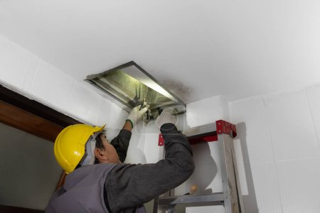 Téléchargez les photos : Worker fix leaking pipe in ceiling ,close-up of a stain on the ceiling. - en image libre de droit