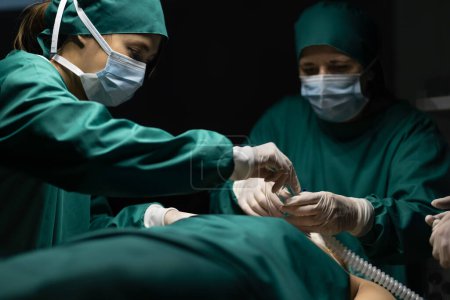 Téléchargez les photos : Équipe médicale effectuant la chirurgie en salle d'opération. - en image libre de droit