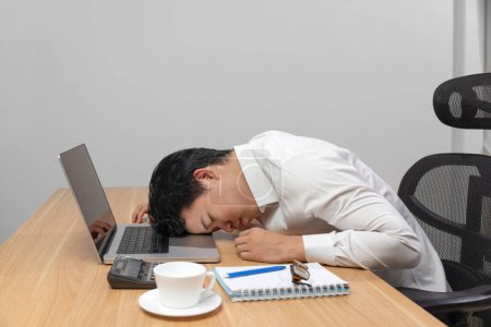 Téléchargez les photos : Man with narcolepsy is fall asleep on office desk.Narcolepsy is a sleep disorder that makes people very drowsy during the day. - en image libre de droit