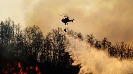 Foto de Helicóptero de extinción de incendios llevar cubo de agua para extinguir el fo - Imagen libre de derechos