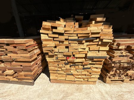 Lumber planks stack in the sawmill.  Stacked of woods on ground in furniture factory