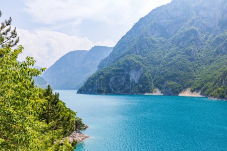 Landscape view of big lake between mountains at summer day. Travel background image with Piva lake in Montenegro