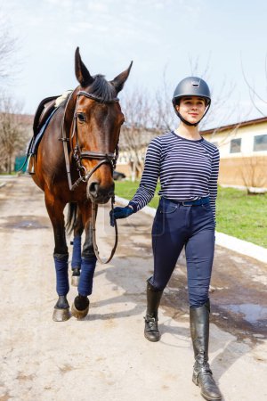 Junge Reiterin geht mit ihrem Pferd zum Training.