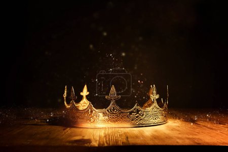 Bild der schönen Königin oder Königskrone über dem Holztisch. Jahrgang gefiltert. Mittelalterliche Fantasie