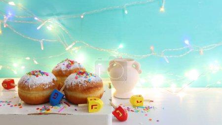 Photo for Image of jewish holiday Hanukkah of doughnut and wooden spinning tops with letters that mean, a great miracle happened here - Royalty Free Image