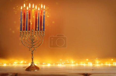 Bild des jüdischen Feiertags Chanukka mit Menora (traditionellem Kandelaber) und Kerzen über Lichtergirlanden