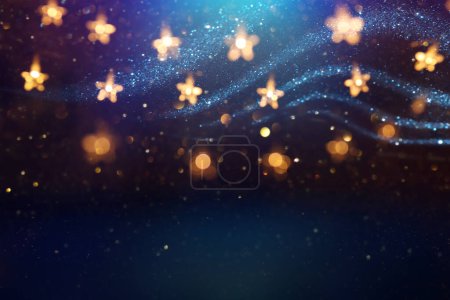 Photo for Christmas warm gold garland lights over dark background with glitter overlay - Royalty Free Image