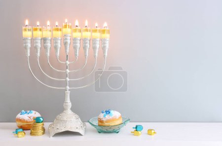 Foto de Imagen religiosa de las vacaciones judías fondo de Hanukkah con menorah (candelabros tradicionales), donut y velas - Imagen libre de derechos