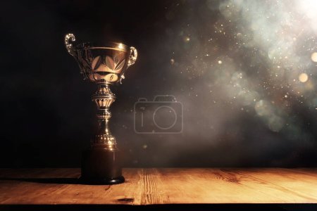 Photo for Image of gold trophy with sparkly overlay over dark background - Royalty Free Image