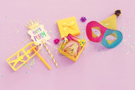 Téléchargez les photos : Concept de célébration Pourim (fête de carnaval juif) sur fond de bois violet - en image libre de droit