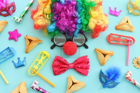 Purim celebration concept (jewish carnival holiday) over blue background. Top view, flat lay