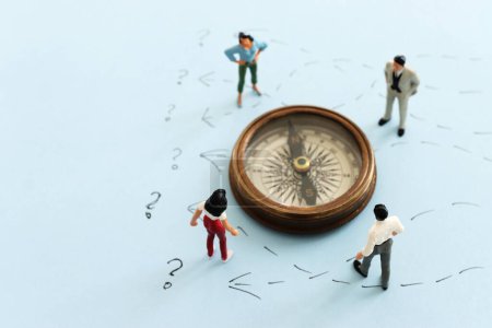 Concept image of people thinking about solving a problem and looking at compass for direction
