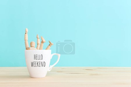 Téléchargez les photos : Figurine en bois sautant de tasse à café avec le texte bonjour week-end - en image libre de droit