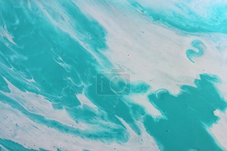 art photography of abstract marbleized effect background with turquoise and white creative colors. Beautiful paint.