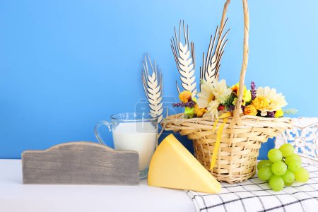 Foto von Milchprodukten vor blauem Hintergrund. Symbole des Feiertags - Shavuot