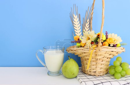 Foto von Milchprodukten vor blauem Hintergrund. Symbole des Feiertags - Shavuot