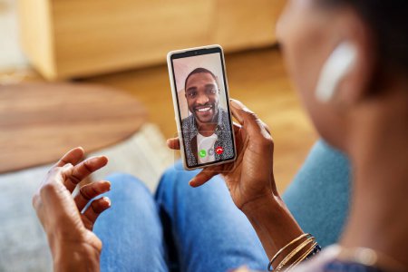 Photo for Black woman enjoying video call using smartphone with boyfriend. Close up of african american man on mobile phone while having a conversation with girlfriend during videocall. Detail of woman hand holding phone talking to her husband. - Royalty Free Image