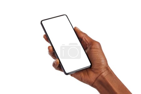 Photo for Close up of black woman hand holding smartphone against white background with copy space. African american woman hand holding cellphone with blank screen. Showing empty screen of mobile phone isolated. - Royalty Free Image
