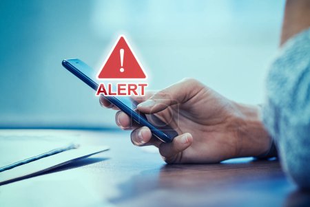 Photo for Emergency alert security message pop up on phone screen. Woman hand holding smartphone while receiving an official emergency alert notification from government. - Royalty Free Image