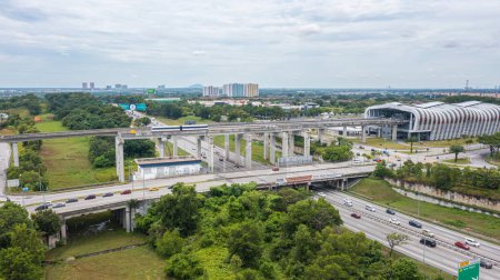 Foto de Malasia - 9 de octubre de 2022: Vista aérea de una autopista con puente ferroviario. Vista superior de la carretera de asfalto atravesada por la vía del tren. Infraestructura de transporte de tráfico. Vista superior foto aérea carretera autobahn. - Imagen libre de derechos