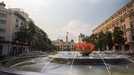 Téléchargez les photos : Ho Chi Minh Ville, Vietnam - 07 novembre 2022 : Palais de l'indépendance avec une fontaine d'eau sur la place nationale de Saigon. Longue exposition avec éclaboussure d'eau soyeuse. Paysage urbain de la métropole d'Indochine - en image libre de droit