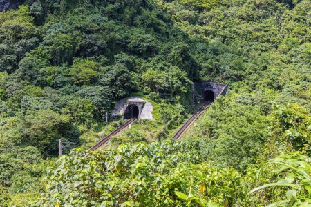 Téléchargez les photos : Parc national de Taroko, Taïwan - 23 mai 2023 : Une image captivante met en valeur la beauté pittoresque de deux tunnels ferroviaires traversant le majestueux paysage montagneux côtier du sud-est de Taiwan - en image libre de droit