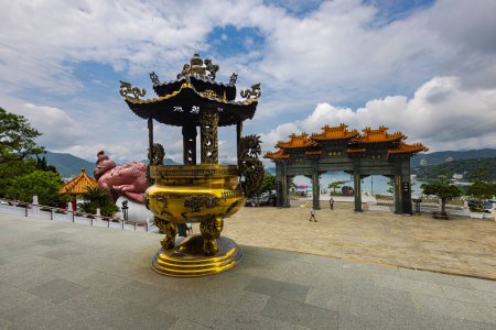 Foto de Sun Moon Lake, Taiwán - 24 de mayo de 2023: El encantador templo de Wenwu en Sun Moon Lake, Taiwán, sorprende con su gran arquitectura, colores vibrantes y aura sagrada. Santuario de Oración de Oro con velas - Imagen libre de derechos