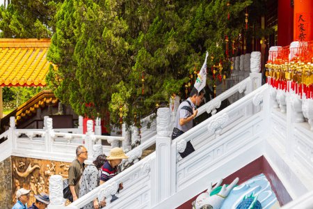 Foto de Sun Moon Lake, Taiwán - 24 de mayo de 2023: El encantador templo de Wenwu en Sun Moon Lake, Taiwán, sorprende con su gran arquitectura, colores vibrantes y aura sagrada. Grupo de turistas subiendo la escalera - Imagen libre de derechos