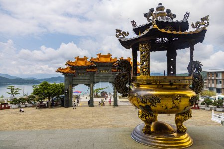 Foto de Sun Moon Lake, Taiwán - 23 de mayo de 2023: El encantador Templo de Wenwu, asombra con su gran arquitectura, colores vibrantes y aura sagrada. La mujer pone velas en el santuario para rezar - Imagen libre de derechos