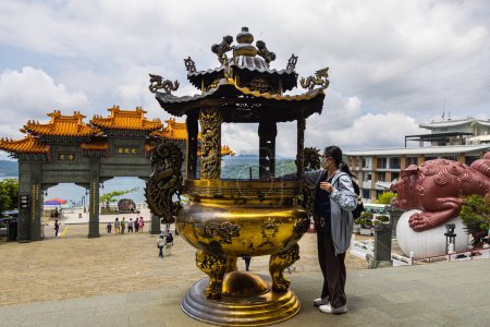 Photo for Sun Moon Lake, Taiwan - May 23, 2023: The enchanting Wenwu Temple, astounds with its grand architecture, vibrant colors, and sacred aura. Woman puts candles in the shrine For praying - Royalty Free Image
