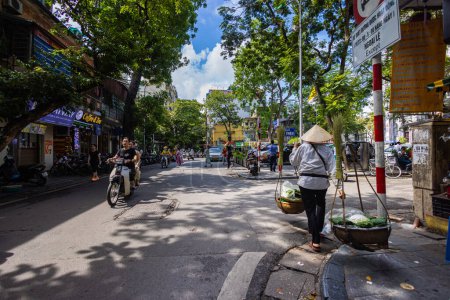 Photo for Hanoi, Vietnam - May 28, 2023: Enchanting Old town streets reveal a vibrant tableau: motorcycles and bicycles whizzing by, creating a melodic cacophony. This energetic scene showcases Vietnam culture - Royalty Free Image