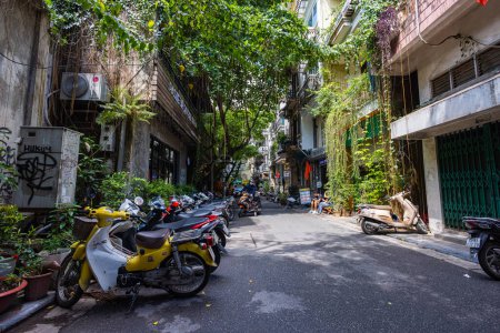 Téléchargez les photos : Hanoi, Vietnam - 28 mai 2023 : Des rues enchanteresses de la vieille ville révèlent un tableau vibrant : motos et vélos défilent, créant une cacophonie mélodique. Cette scène énergique met en valeur la culture vietnamienne - en image libre de droit