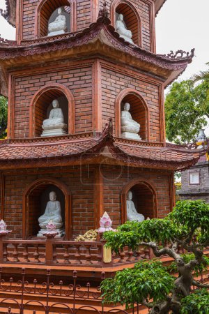 Foto de Hanoi, Vietnam - 28 de mayo de 2023: La pagoda Tran Quoc, situada en una pequeña isla en el lago oeste de Hanoi, es un antiguo templo budista conocido por su rica historia, su alta estupa esbelta y su hermoso jardín. - Imagen libre de derechos