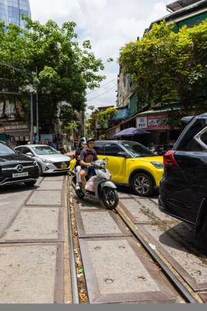 Photo for Hanoi, Vietnam - May 28, 2023: Enchanting Old town streets reveal a vibrant tableau: motorcycles and bicycles whizzing by, creating a melodic cacophony. This energetic scene showcases Vietnam culture - Royalty Free Image