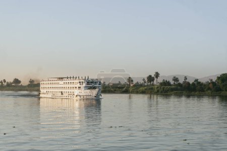 Cette photographie saisit le contraste saisissant entre les loisirs et l'industrie le long du Nil, une juxtaposition qui incite à la contemplation de l'impact environnemental des voyages modernes. Comme toi