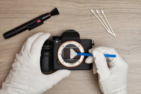 Foto de Limpieza de un sensor de cámara digital de cuadro completo moderno mediante un hisopo de sensor - Imagen libre de derechos