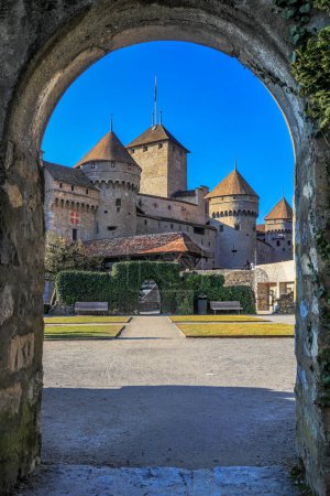 Das mittelalterliche Schloss Chillon am Genfer See von einem Steinbogen aus gesehen