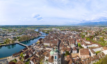 Panorama of aerial views of the old town of Solothurn city with St. Ursus Cathedral - a Swiss heritage site of national significance - at the foreground and the Aare River on the left. 