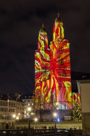 Téléchargez les photos : Zurich, Suisse - 02. Janvier 2022 : Le nouveau spectacle de lumière de l'année dans le centre-ville de Zurich avec de beaux motifs graphiques projetés sur l'église Grossmuenster. - en image libre de droit