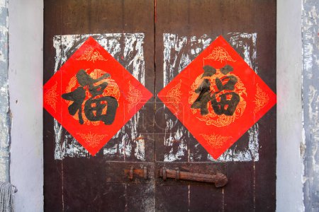 Photo for Two red Chinese blessing "Fu" (it means luck and prosperity) for Chinese new year replaced the old ones for the New Year on the traditional chinese wooden door - Royalty Free Image