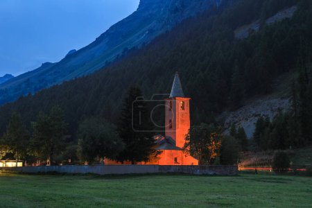 Foto de Iglesia de San Lurench en el pueblo de Sils im Engadin con iluminación durante la hora azul. Alpes suizos, Suiza, Europa. - Imagen libre de derechos