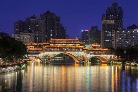 Téléchargez les photos : Chengdu, Chine - 13 octobre. 2023 : Célèbre monument de Chengdu - Anshun pont au-dessus de la rivière Jin illuminé la nuit avec des gratte-ciel modernes et Agriculture Bank of China en arrière-plan - en image libre de droit